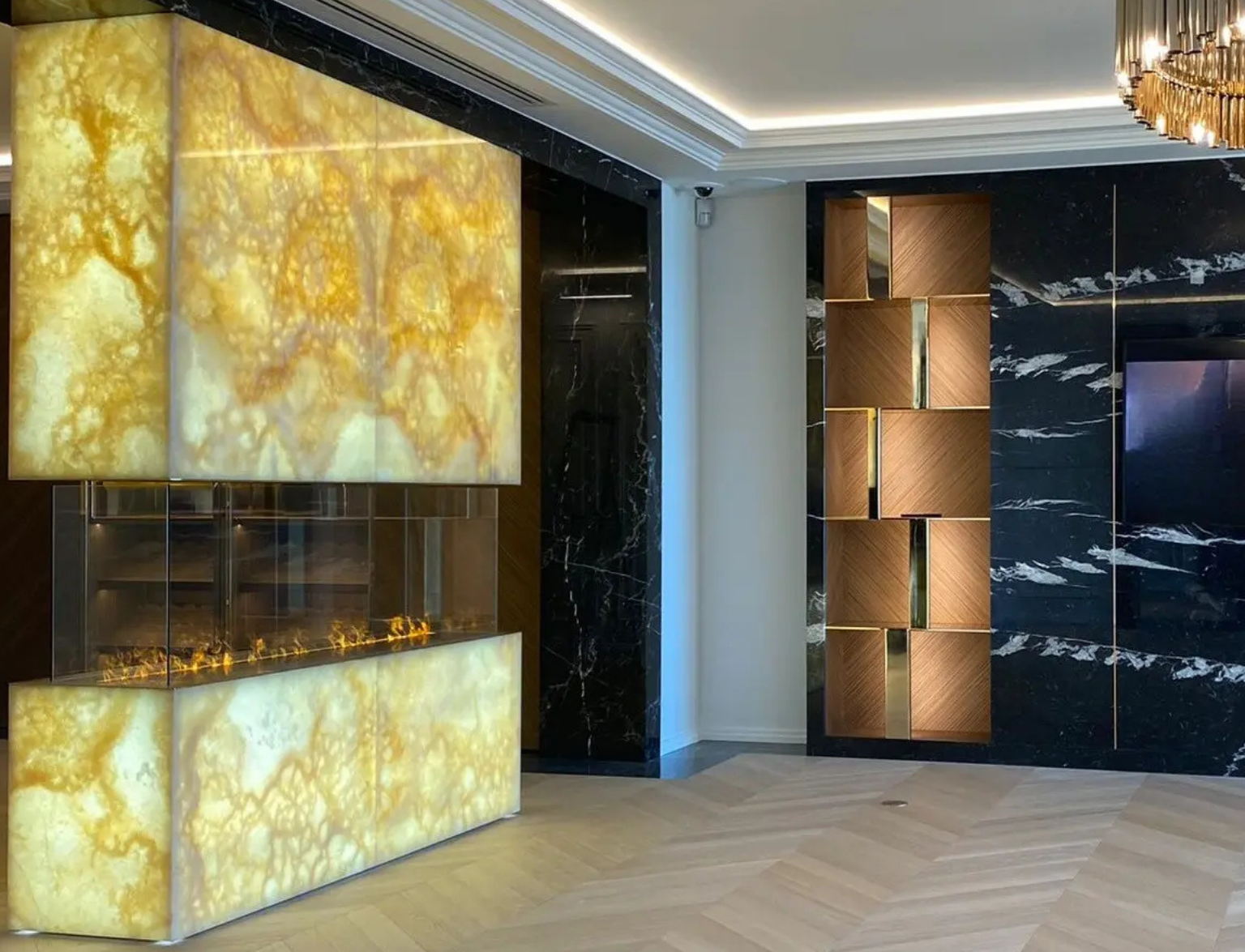 Cheminée en quartzite Patagonia rétroéclairé avec habillage mural en marbre noir dans un intérieur de luxe