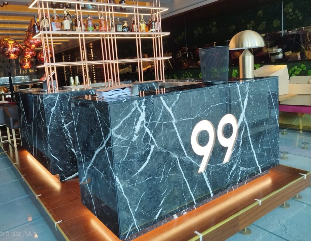 Banque d’accueil sur mesure en marbre Noir Marquina avec éclairage intégré dans un restaurant haut de gamme à Monaco.