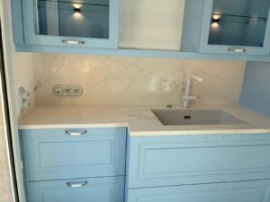 Cuisine élégante avec plan de travail, évier intégré et crédence en Dekton Aura effet marbre blanc veiné.