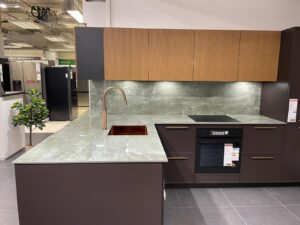 Cuisine contemporaine avec plan de travail, crédence et évier intégré en céramique Emerald Green effet marbre vert.