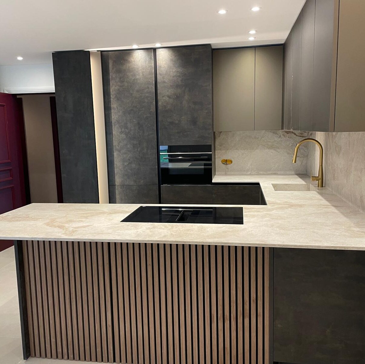 Cuisine contemporaine avec plan de travail, crédence et îlot central en quartzite Taj Mahal dans un appartement haut de gamme.