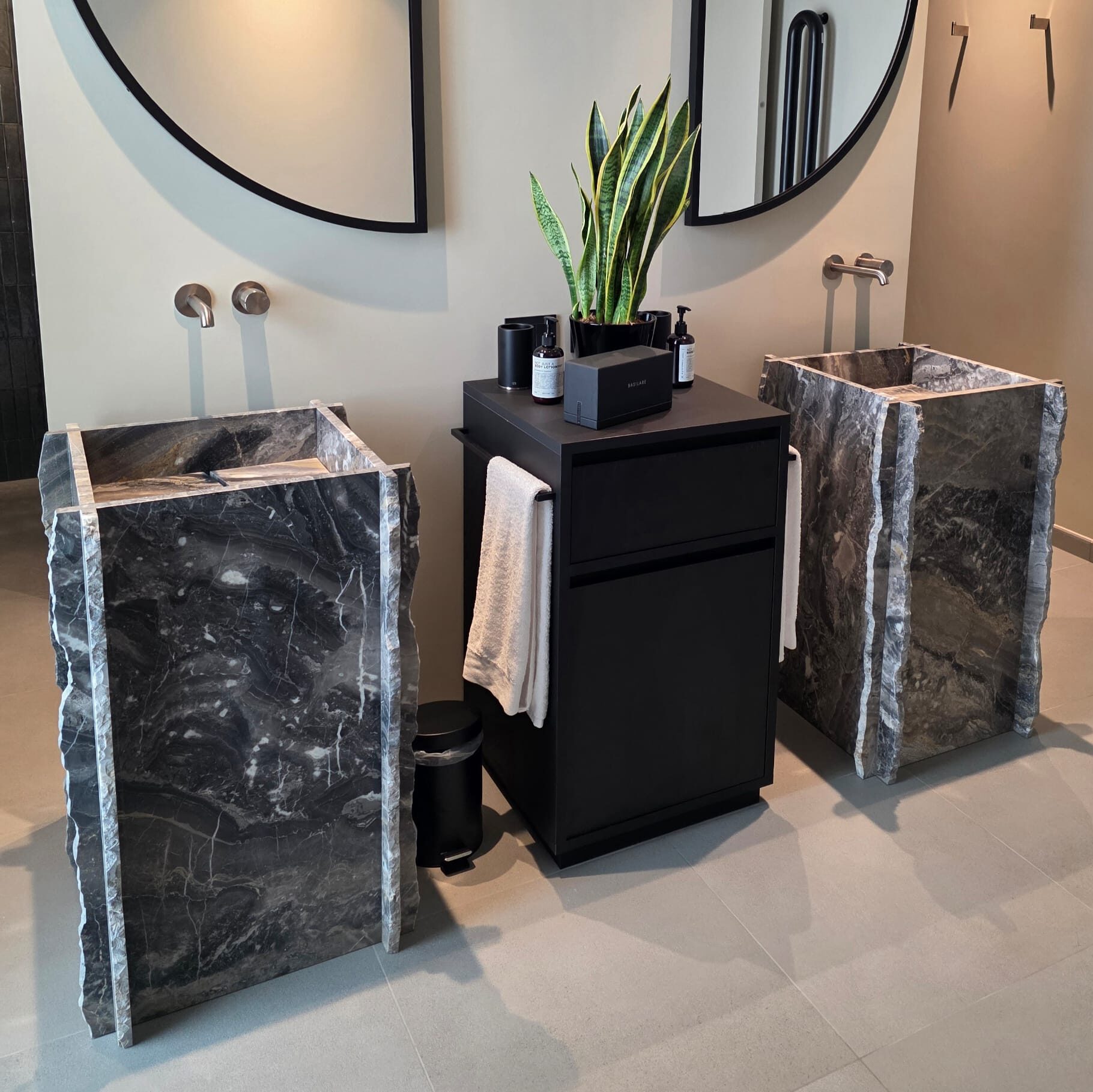 Vasques monolithiques sur pied en marbre naturel sombre réalisées sur mesure pour les salles de bain d’un hôtel de luxe à Rimini.